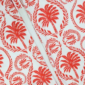 Vue détaillée du motif de palmier rouge et de feuilles tropicales sur tissu blanc