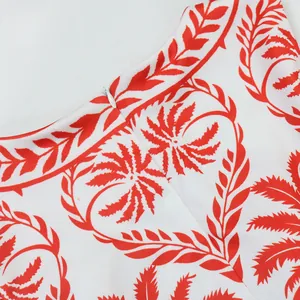 Gros plan de la fermeture éclair et de l'imprimé palmier rouge sur tissu blanc