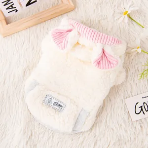 Dettaglio del gilet in pile bianco per animali con bordo a coste rosa e orecchie