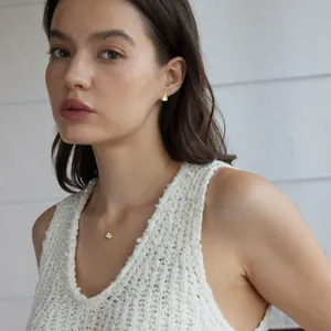 Model trägt ein elegantes 18k vergoldetes Halsketten- und Ohrringset mit Steinen