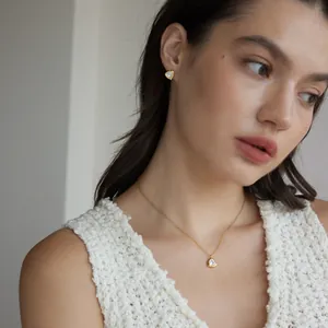 Elegantes 18k vergoldetes Set aus Dreieck-Halskette und Ohrsteckern, am Modell präsentiert