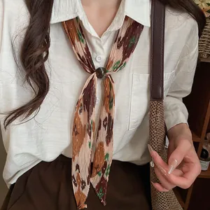 Macro view of a retro pleated print necktie necklace styled on a white linen shirt.
