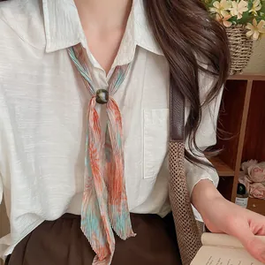 Close-up of vintage pleated printed scarf necktie necklace shown on a model outfit