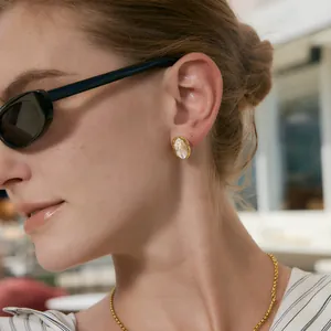 Gros plan d'un mannequin portant des boucles d'oreilles en acier titane avec strass marquise