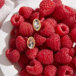 Boucles d'oreilles marquise en acier doré et strass sur des framboises rouges