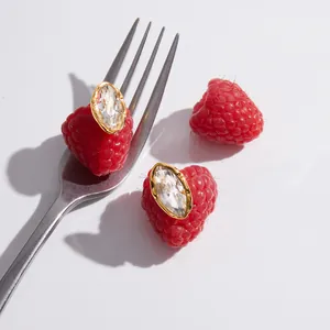 Vue détaillée de boucles d'oreilles en acier doré avec cristaux en taille marquise.