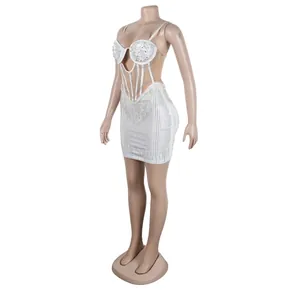 Detailed view of white rhinestone and pearl embellished bodycon dress with cutouts.