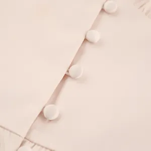 Detailopname van elegante met stof beklede knopen op een roze satijnen Franse jurk