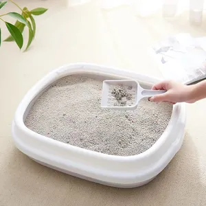 White semi-enclosed anti-splash cat litter box with scooper in a cozy home setting
