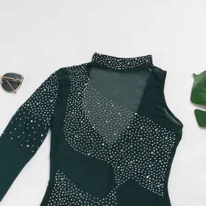Detalle de un vestido de malla verde oscuro con elegantes adornos de strass brillantes
