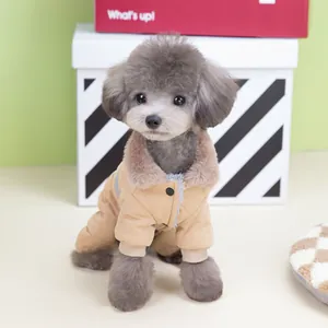 Detailed view of a small poodle wearing a thick quilted tan winter dog coat with a fur collar.