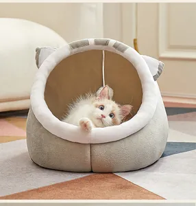 Vista detallada de un gatito blanco descansando en una acogedora cama para gatos gris