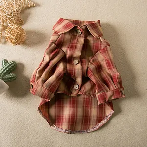 High-quality detail of a red and tan plaid pet shirt featuring classic buttons and collar