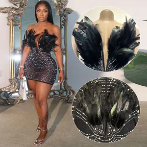 Detailaufnahme des sexy Bodycon-Kleides mit Federn, Strasssteinen und Perlenverzierung