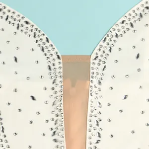Close-up detail showing sparkling rhinestones and sheer mesh on a sexy white plunge dress.