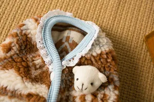 Dettaglio di un caldo gilet invernale per animali con orsetto di peluche e colletto in pizzo