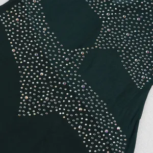 Primer plano de pedrería brillante en forma de estrella sobre tela de malla verde