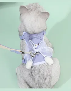 Dettaglio dell'imbracatura viola per gatti con fiocco in pizzo e disegno di orso