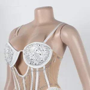 Detailed shot of white bodycon dress with rhinestone pearls and plunging neckline