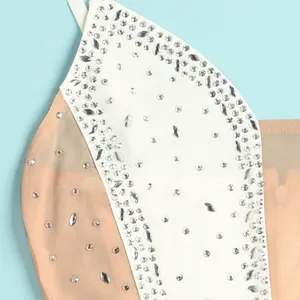 Macro detail of sparkly clear rhinestones on white and beige sheer mesh camisole dress