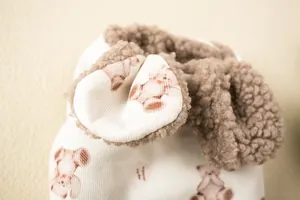 Close-up of pet vest featuring teddy fleece trim and cute bear print