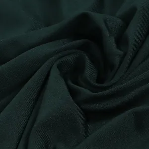 Primer plano de la textura acanalada de la tela de malla verde oscuro para un vestido.