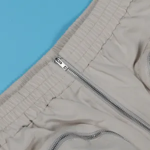 Detail view of beige cargo skirt featuring elastic waistband and silver zippers.