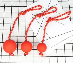 Detail van drie verschillende maten rode rubberen hondenballen met stevige touwen