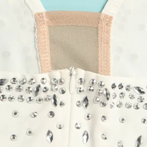 Close-up detail of sheer mesh panel and sparkling rhinestones on white evening dress.