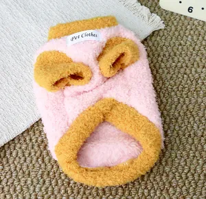 Detailed macro view of thick pink and yellow fleece pet sweater with Pet Clothes label.