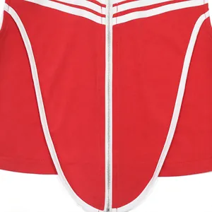 Detailopname van een rode mouwloze top met witte ritssluiting en contrasterende bies
