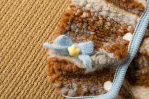 Dettaglio gilet per animali in sherpa con fiocco azzurro e bottone a stella