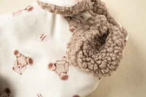 Close-up of pet clothing showing soft bear pattern fabric and brown fleece trim details