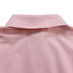 Vista detallada del cuello camisero rosa y la textura de tela del vestido