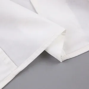 Macro detail of high-quality white cotton shirt fabric with neat hem stitching and texture