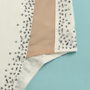 Detailed view of sparkling hot-fix rhinestones and sheer mesh panel on a white evening dress