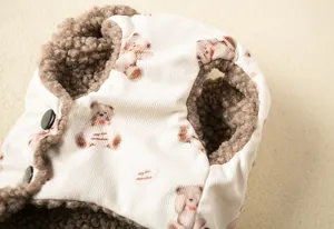 Close-up detail of the soft fleece lining and cute teddy bear print on a pet vest