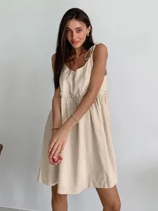 Elegant beige cotton-linen sundress with tie straps for a stylish summer resort look