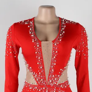 Dettaglio di una tuta rossa con perle, strass e inserto in rete trasparente elegante