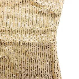 Nahaufnahme goldener Paillettenstreifen auf elegantem Abendkleid aus Netzgewebe.