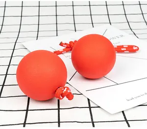 Detail van oranje-rode massieve rubberen hondballen met stevig gevlochten touw