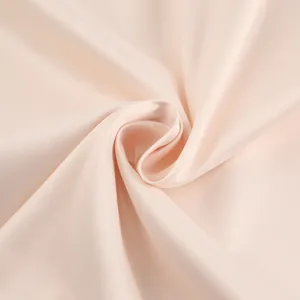 Close-up detail van gladde en elegante lichtroze satijnen stof met een luxe glanzende finish