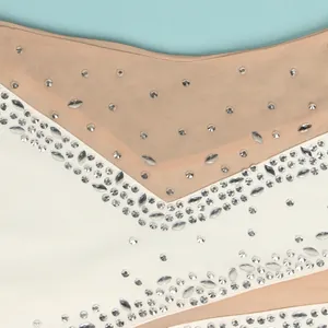 Close-up of sparkling silver rhinestones on a mesh and white fabric dress detail