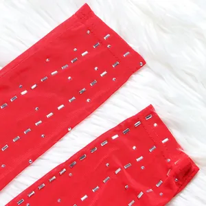 Detailed close-up of red mesh fabric featuring sparkling silver rhinestone embellishments