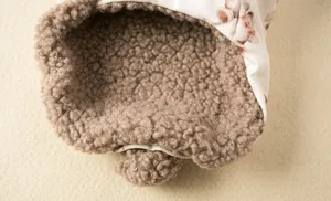 Close-up detail of soft brown sherpa fleece lining on a floral pet winter vest coat