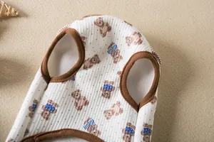 Detail view of a white pet vest with cute teddy bear pattern and ribbed fabric texture.