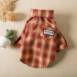 Detailed macro view of a red and beige plaid dog shirt featuring a stylish pocket patch