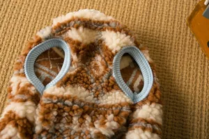 Primo piano del caldo gilet in peluche per animali con motivo geometrico marrone