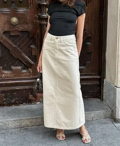 Full-length view of a beige high-waisted denim maxi skirt paired with a black t-shirt