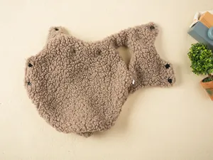 Detailed macro view of brown fleece pet vest showing soft textured fabric and black snaps
